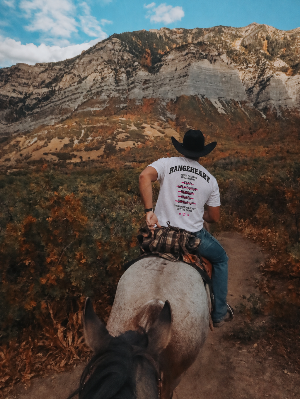 White Still Riding tee back graphic worn on horseback