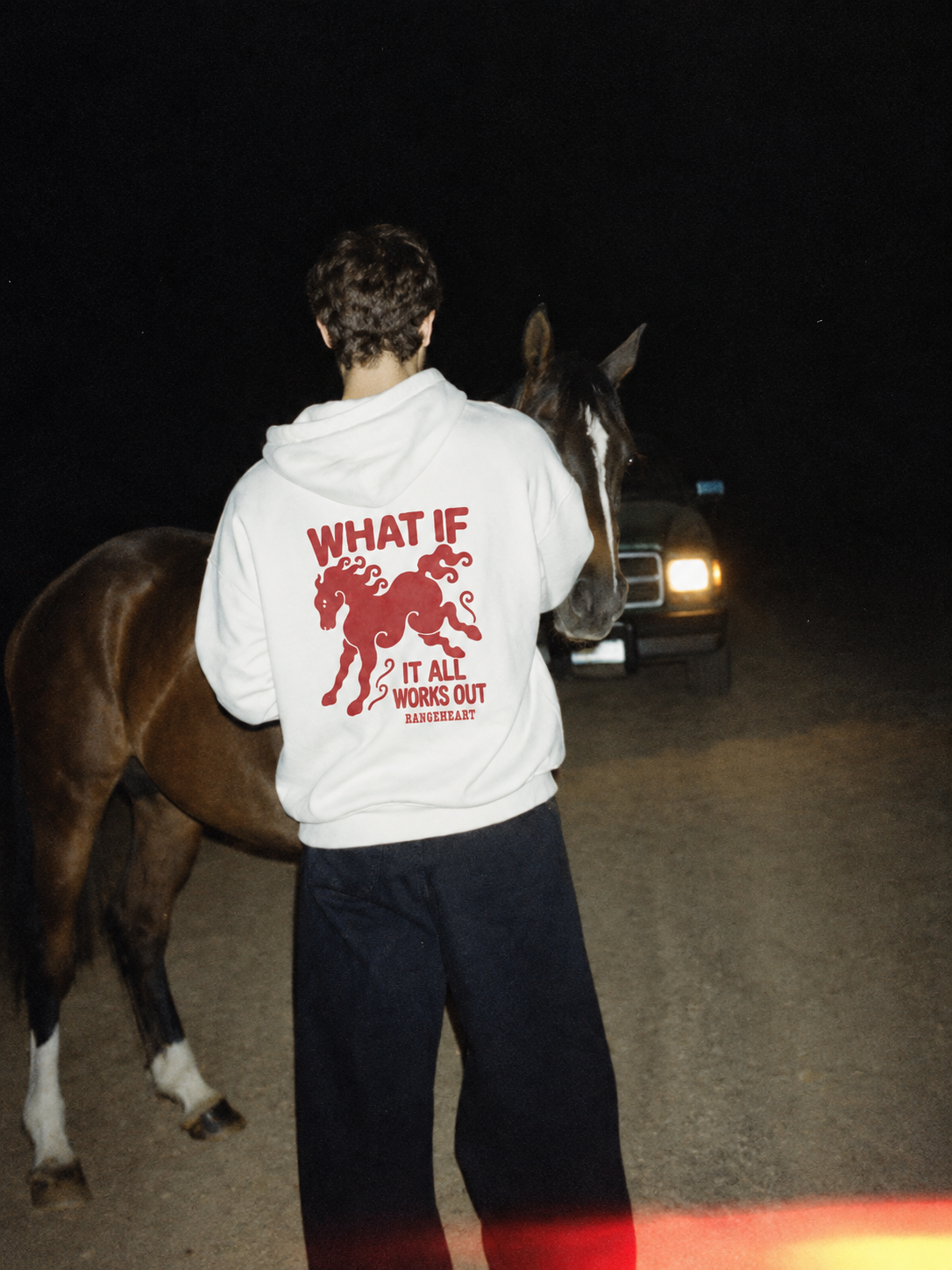 Red horse and slogan on the white What If hoodie at night