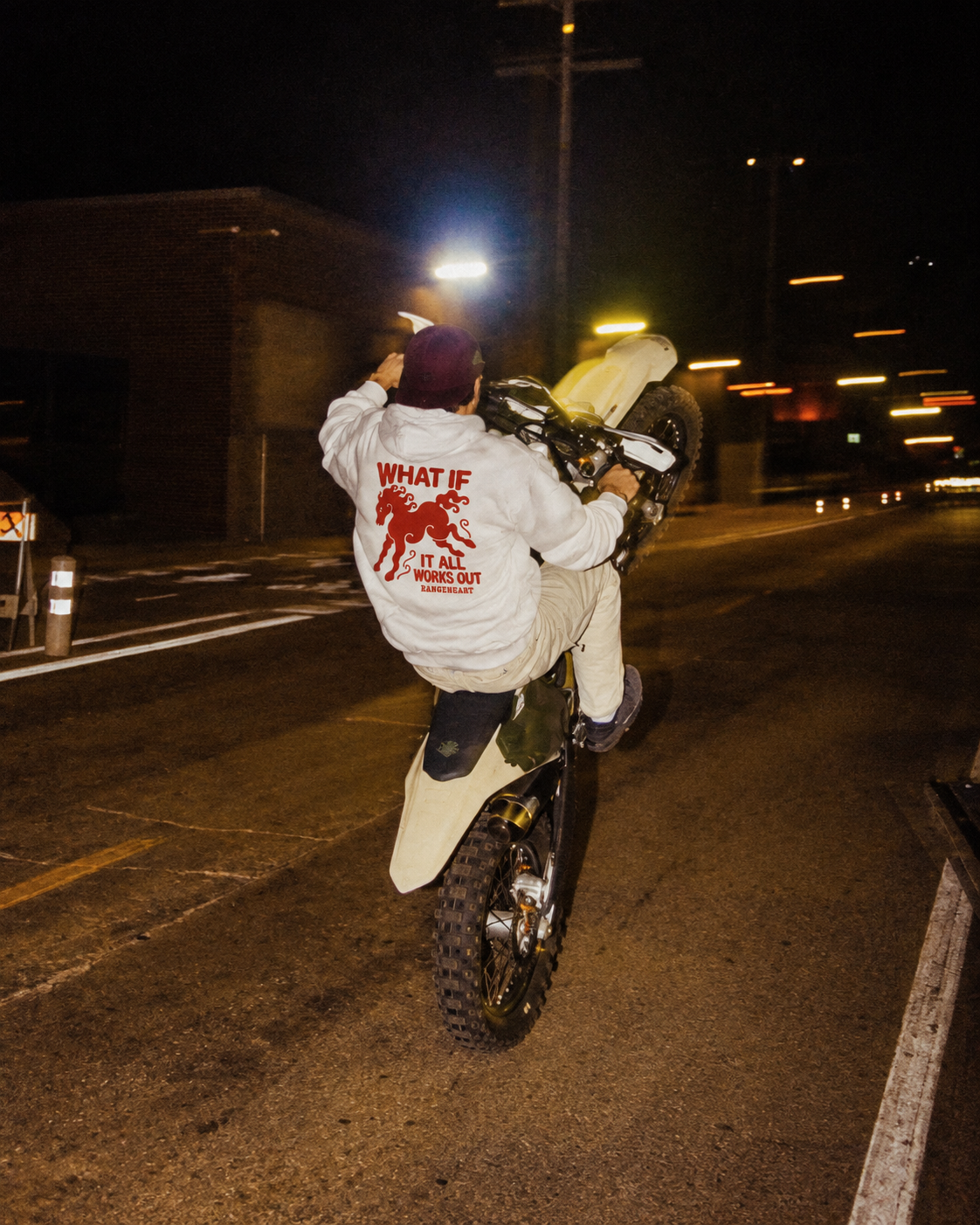 White What If hoodie back graphic during a nighttime dirt-bike ride