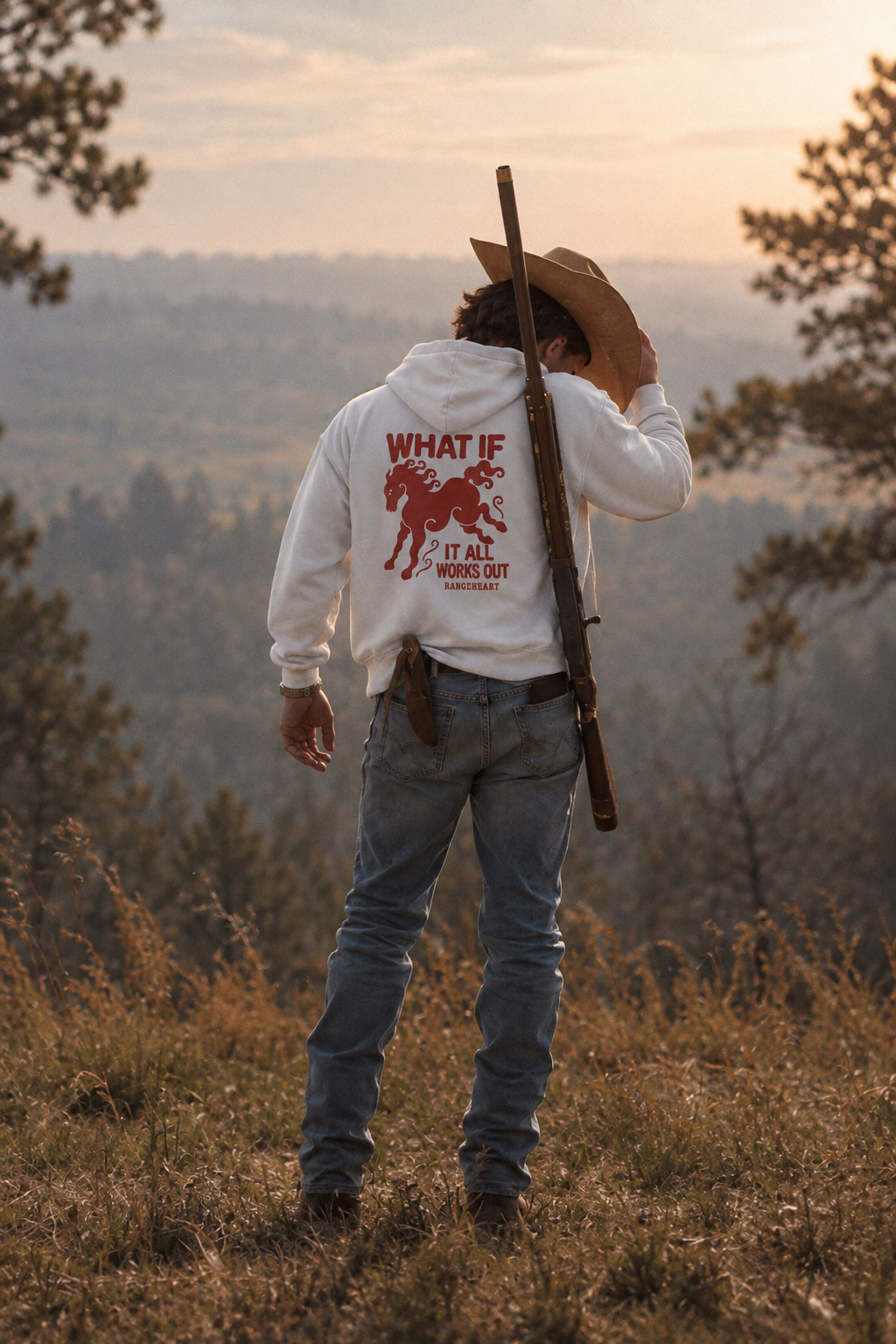 White What If hoodie back graphic on a hillside at sunset